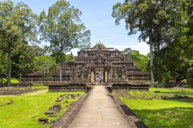 Angkor Thom 'daki antik Phimeanakas Tapınağı' na giden taştan bir geçit. Ağaçlar ve yeşilliklerle çevrili.