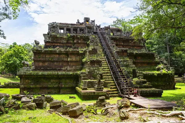 Angkor Thom 'daki antik Phimeanakas Tapınağı' na giden taştan bir geçit. Ağaçlar ve yeşilliklerle çevrili.