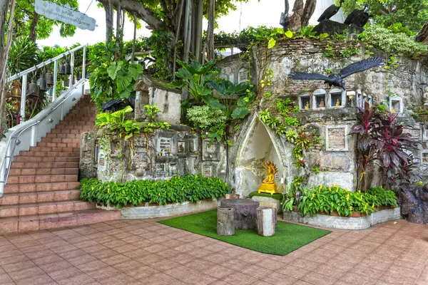 Bangkok, Tayland 'daki Wat Ratchabophit' te yemyeşil bir bahçeye yerleştirilmiş altın bir Buda heykeli olan küçük bir tapınak.