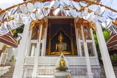Bangkok, Tayland 'daki Wat Ratchabophit' te gümüş dua yapraklarıyla süslenmiş süslü bir köşkte altın bir Buda heykeli.