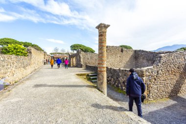 POMPEII, ITALY 2025 Mart 02: Turistler, Vezüv Dağı 'nın patlaması sonucu yok olan antik Roma şehri Pompei' nin iyi korunmuş kalıntılarını keşfediyorlar.