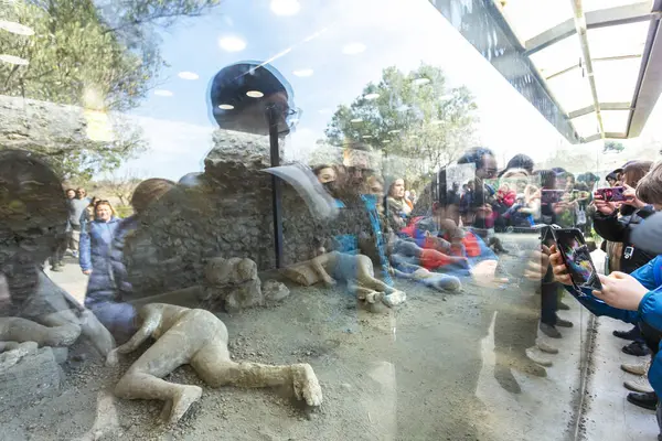 POMPEII, ITALY 2025, Mart 02: Turistler, Pompeii, İtalya 'nın arkeolojik sahasında Vesuvius Dağı' nın patlamasından korunmuş bir insan kurbanın alçısını gözlemlediler.