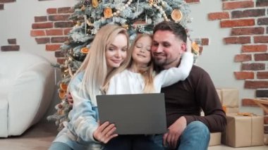 Küçük bir kız büyükannesi ve büyükbabasıyla çevrimiçi bir video görüşmesi sırasında ailesine şefkatle sarılıyor. Kız uzun zamandır akrabalarını görmemiş ve onlarla iletişimden etkilenmiş. Mutlu Noeller.