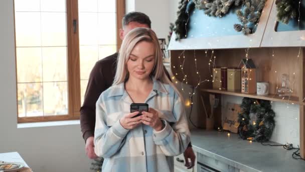 Homem Aproxima Sua Esposa Cozinha Decorada Natal Abraça Ternamente Uma — Vídeo de Stock