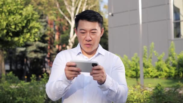 Çinli Yakışıklı Erkek Şehirli Profesyonel Işadamı Cep Telefonu Uygulamasını Kullanarak — Stok video