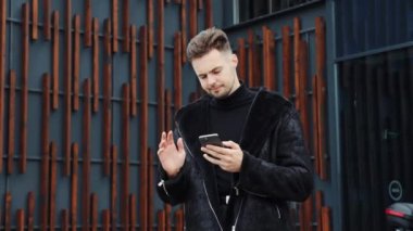 Stresli genç adam cep telefonu ekranına bakıyor, dışarıda kötü haberlerle dolu bir mesaj ya da e-posta almaktan rahatsız oluyor. Mutsuz erkek kullanıcı kötü elektronik cihaz çalışmasından memnun değil