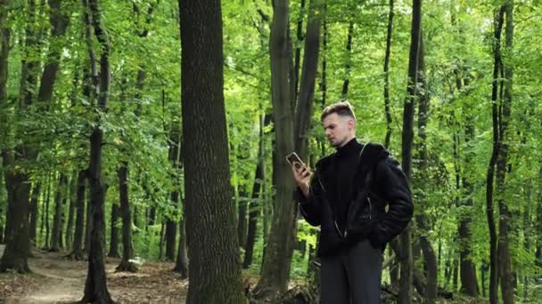 Młody Zestresowany Mężczyzna Jesiennej Kurtce Stojący Zewnątrz Zagubiony Drewnie Żadne — Wideo stockowe