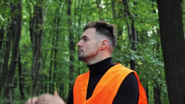 救助隊からのオレンジベストのボランティアは 森の中の人々を見つけるための操作に参加します 森の中で迷子になった少女を探している男 男は大声で叫ぶ — ストック動画