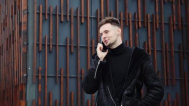 Dışarıda cep telefonuyla konuşan başarılı havalı adam. Kendine güvenen, şık ve kalın elbiseli bir iş adamı dışarıda dostça bir konuşma yapıyor. Sonbahar ya da kış günü şehir merkezinde bir adam arıyor.