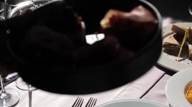 Bir garson seçkin bir İtalyan restoranında bruschetta 'yı masaya koyar. Geleneksel İtalyan İspanyol yemeği, jambonlu bruschetta, peynirli, zeytinli kuru domates, salata ve lezzetli sandviç büfesi aperatifi.