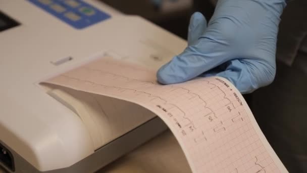 心臓科医は患者に心臓グラムを作る プロの医師の女性の手は 現代のクリニックで病気の女性のさらなる検査のための心血管を保持しています 医療の最新技術 — ストック動画