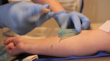 Mavi koruyucu eldivenli kadın doktor hastanede koronavirüs için hastadan kan örneği alıyor. Klinik araştırma. Klinikteki laboratuvar. Covid2023 Salgın ve Tıp Konsepti