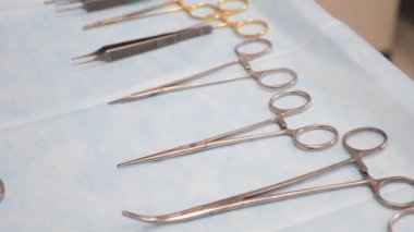 Klempler ve cerrahi makas, ameliyat için cerrahi aletler ameliyathanede hazırlanıyor, masada klinikte ameliyat için dezenfekte edilmiş metal aletler, cerrahi konsept.