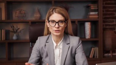 Gözlüklü bir iş kadını kamerayla konuşuyor. İş görüşmesi yapıyor. İş başvurusunda bulunan kişi uzaktan görüşme için görüntülü konuşma yapıyor. Kadın profesyonel video konferans ile iletişim kuruyor. Web kamerası görünümü