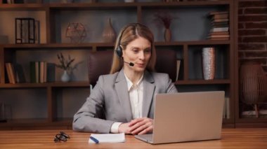 Gülümseyen, kendine güvenen genç bir iş kadını ofiste konferans görüşmesi yapıyor, akıllı kadın yöneticiler konuşuyor online görüntülü iletişim kuran kamera laptopuna bakın, iş görüşmesi konsepti, webcam görüntüsü