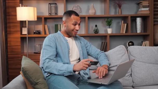 Schöner Afroamerikanischer Mann Der Auf Couch Wohnzimmer Sitzt Und Kreditkarte — Stockvideo