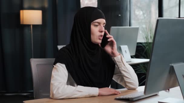 Upptagen Tusenårig Muslimsk Kvinna Kontor Arbetsledare Konsultera Klient Genom Telefon — Stockvideo