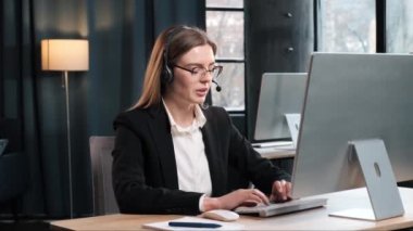 Kulaklıklı ve gözlüklü akıllı iş kadını video çağrısı, çevrimiçi çağrı merkezi, operatör Webinar video konferansında müşteriyle konuşuyor, web kamerası görüntülü ofis sohbeti e-öğreniyor