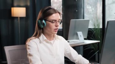 Charming beautiful manager in wireless headphones and white shirt lead distant negotiations with with a business partners. Employer talk with applicant telling using video call app, job interview