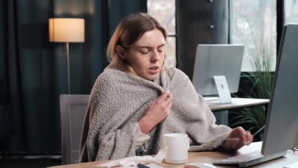 オフィスから仕事中に鼻を吹いている若い女性がインフルエンザにかかりました Pcのラップトップのキーボードを入力します 健康上の問題が発生する風邪のくしゃみをキャッチ 低温室内のために苦しんでいます — ストック動画