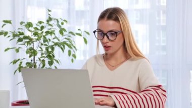 Joyful happy caucasian business woman girl winner lucky enjoys victory emotionally raises hands up shouting winning with laptop online achievement offer bet computer game win success crazy shout