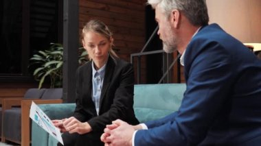 Businesswoman holding a chart of the companys income to explains the details making business agreement contract deal, concluding trust partnership contract during negotiations at conference table