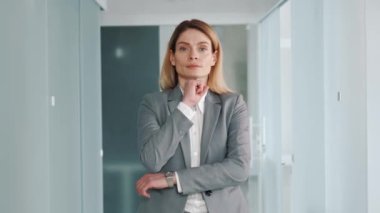 Middle aged confident focused business woman in formal suit standing in modern light office puts hand on chin smile looks at camera feels happy. 40s pretty positive female face portrait concept
