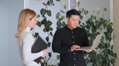 Startup investment diverse business meeting between asian investor and caucasian female startupper businesswoman. Business poeople discussing new project, financial market data using laptop