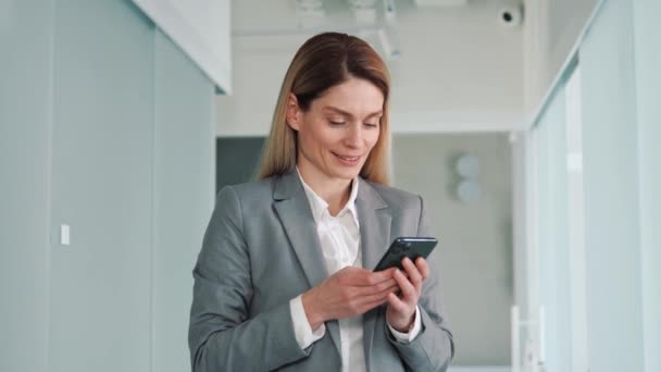 Šťastná Sebevědomá Mladá Podnikatelka Stojící Kancelářské Hale Dívající Mobilního Telefonu — Stock video