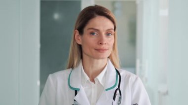 Sağlık Kliniğinde Gülümserken Kameraya Dönen Güzel Beyaz Kadın Profesyonel Tıp Doktorunun Portresi. Başarılı, kendine güvenen beyaz önlüklü doktor.