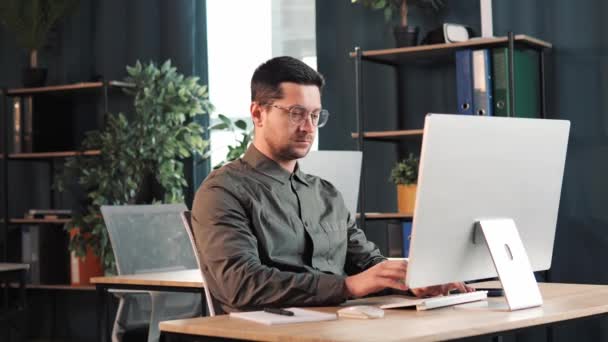 Mężczyzna Programista Pracuje Laptopie Siedząc Biurkiem Pokoju Biurowym Wolny Strzelec — Wideo stockowe