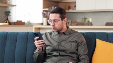 Close up upset adult man in glasses mad unhappy businessman feeling annoyed with using broken smart phone low battery problem angry having problem with mobile telephone frustrated bad news what