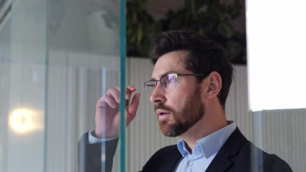 Successful Tired Overworked Man Approaches Glass Wall Removes His Glasses — Stock Video