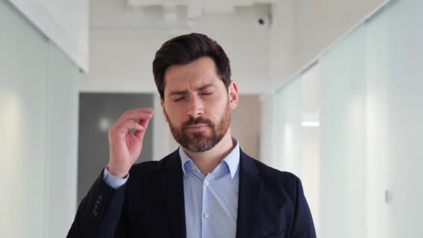 オフィスでの圧倒的な仕事の要求の結果として頭痛が発生しない疲れビジネスマン感 高気圧は彼の健康と生産性に悪影響を与えています — ストック動画