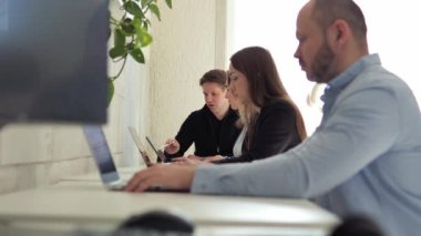 Bir grup insan, görevlerini verimli bir şekilde tamamlamak için fikirlerini ve stratejilerini tartışarak işlerine odaklanmış durumda. Yaratıcı dost alan programcılar için üretken ve ilham verici bir ortam yaratıyor