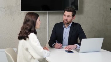 Başarılı bir iş adamı, modern bir ofiste iş için genç ve zeki bir bayanla röportaj yapıyor. Profesyonel saygılı atmosfer ve yoğun sohbetler. Her iki taraf da olumlu ve umutlu