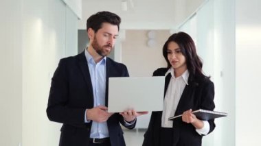 Ofis koridorunda, iki kadın ve erkek meslektaşı dizüstü bilgisayar kullanarak yeni bir projede işbirliği yapıyorlar. Kadın ve erkek arasındaki takım çalışması onların hırslı hedefleriyle, birlikte konuşmalarıyla besleniyor.