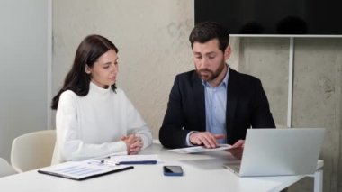 Moda kıyafetli akıllı ve şık bir işadamı bir kadın yatırımcıyla konuşuyor, dijital ürün fiyat artışının grafiklerine bakıyor ve ortak bir ortaklık için birbirleriyle tokalaşıyor.