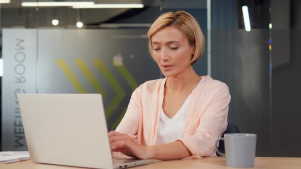 エレガントな 美しく スタイリッシュな女性はノートパソコンで作業し オフィスの彼女の机に座っています 月経痛や胃炎の不快感にもかかわらず 彼女は構成され 彼女の仕事に焦点を当てます — ストック動画