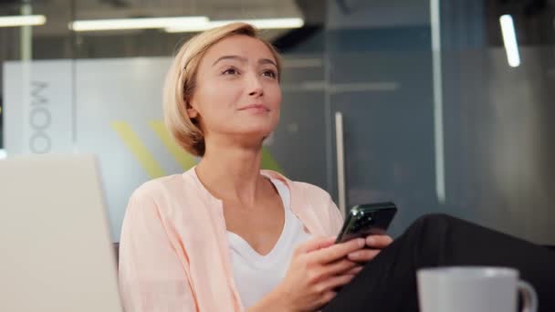 Joven Atractiva Mujer Rubia Sienta Una Mesa Oficina Sosteniendo Teléfono — Vídeos de Stock