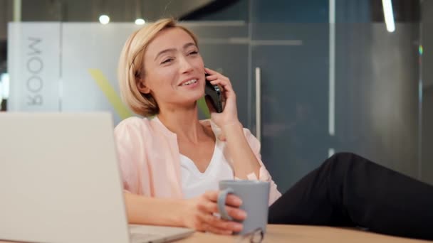 Mulher Loira Bonita Escritório Relaxante Falando Telefone Presumivelmente Com Colega — Vídeo de Stock