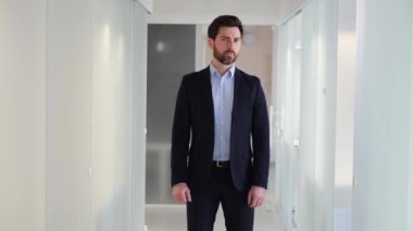 Ofis lobisinde takım elbiseli bir iş adamının ideal portresi profesyonellik ve güven yayar. İletişim, liderlik, karar verme becerileri onun başarısını tanımlayan diğer kritik özelliklerdir.