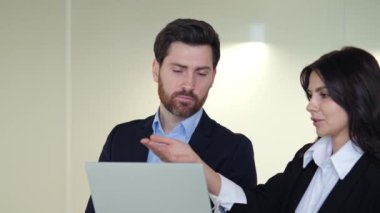 Erkek ve kadın işadamı ofis koridorunda dizüstü bilgisayarla bir projeyi tartışıp ek yatırımlar ve bankacılık sistemlerine odaklanıyor. Modern iş dünyasında takım çalışması.