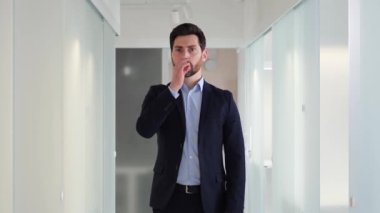 Genç adam, sessiz kalmak için parmağını dudaklarına koydu. Büro çalışanı veya işadamı, profesyonellik ve sağduyu duygularını ifade eden gizli veya hassas bilgilerle uğraşıyor olabilir.