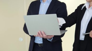 Ofis çalışanları hareketli bir ofis koridorunda yeni bir projede işbirliği yapmakla aktif olarak meşguller. İnsanlar fikirlerini geliştirmek ve geliştirmek için dizüstü bilgisayar kullanıyor, takım çalışması, işbirliği, yaratıcılık