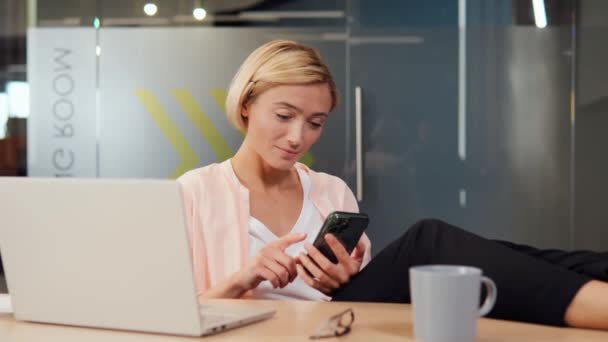 Empresária Multitarefa Sua Mesa Escritório Segurando Seu Telefone Sorrindo Enquanto — Vídeo de Stock