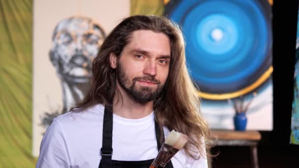 Portrait Handsome Artist Poses His Studio While Holding Painting Brushes — Stock Video