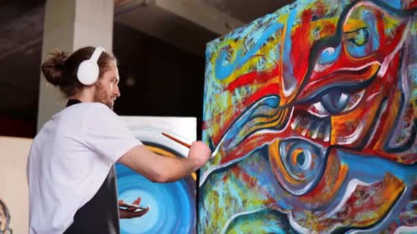 스튜디오 커다란 캔버스 붓으로 헤드폰 재능있는 혁신적 예술가 가색깔 감정적 — 비디오