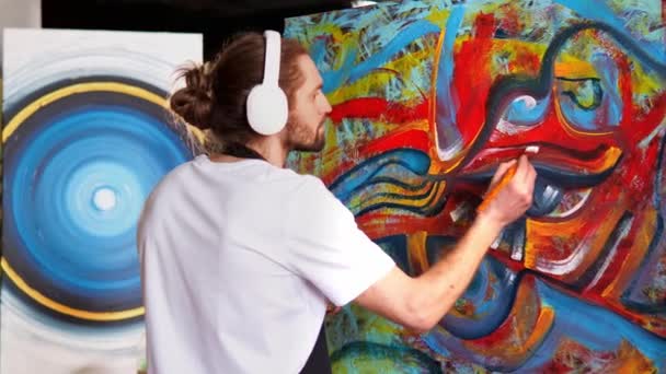 Ταλαντούχος Καλλιτέχνης Στα Ακουστικά Ακούει Μουσική Ενώ Ζωγραφίζει Πινέλο Καμβά — Αρχείο Βίντεο