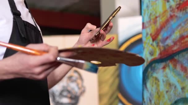 Zbliżenie Artysty Paletą Farb Pędzlem Trzymającym Telefon Komórkowy Odpowiadającym Ważną — Wideo stockowe